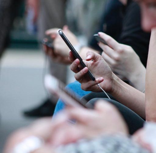 sobergrind-What-is-Emotional-Sobriety-photo-of-a-line-of-hands-on-phone